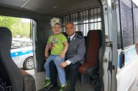 Komisarz Tomasz Obarski na wspólnej fotografii z niepełnosprawnym dzieckiem