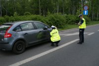 Policjanci ruchu drogowego w trakcie oględzin samochodu