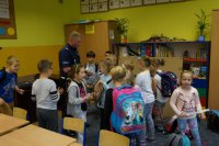 Policjanci w trakcie przekazywania dzieciom elementów odblaskowych