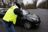 Policjant rejestrujący wykroczenia za pomocą aparatu fotograficznego.