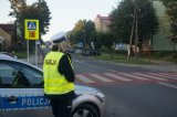 policjantka w mundurze stoi przy drodze przy radiowozie