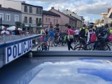 uczestnicy pikniku rowerowego na tle napisu policja