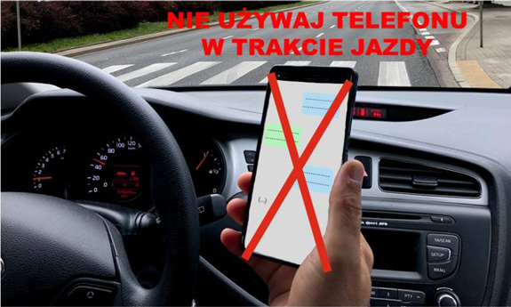 osoba trzyma telefon w ręku podczas jazdy samochodem