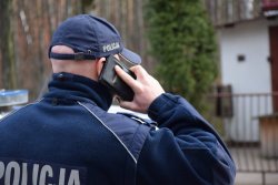 policjant dzwoni przez telefon komórkowy