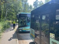 policjant na tle dwóch autobusów