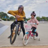 mężczyzna i dziecko oboje na rowerach w skateparku