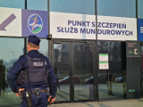 Policjant w mundurze wchodzi do centrum medycznego