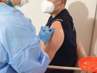 Szczepionka podawana w ramię widoczny policjant w mundurze