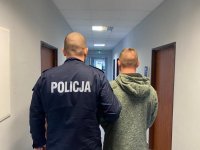 Policjant trzyma za rękę zatrzymanego