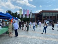 Widok ogólny płyta rynku Jaworzno a na niej ludzie i Biblioteka Miejska w tle