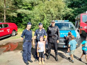 Policjanci i strażak z uczestniczką półkolonii