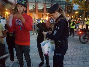 Policjantka rozdaje odblaskowe gadżety