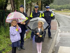 Policjanci z dziećmi w rejonie przejścia dla pieszych