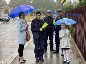 Policjanci z dziećmi i osobą dorosłą w rejonie przejścia dla pieszych