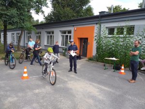 Policjant egzaminuje uczestnika na rowerze egzaminu na kartę rowerową