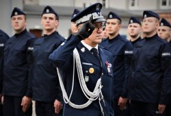 Generał Policji oddaje honor a w tle policjanci