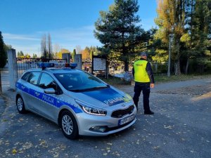 Policjant, radiowóz przy cmentarzu