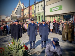 Policjanci i strażak stoją przed ponikiem