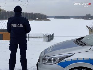 Policjant obserwuje zamarznięty akwen