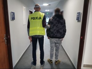 Policjant z zatrzymanym na korytarzu komendy