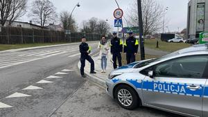 Policjantka zakłada pieszym odblaski na rekę