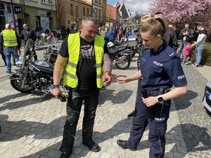 Policjantka zakłada mężczyźnie odblask na rękę
