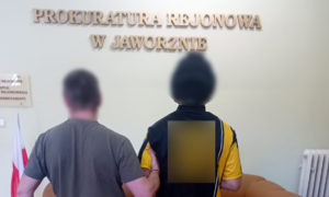 Napis Prokuratura Rejonowa w Jaworznie i policjant z zatrzymanym
