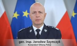 Komendant Główny Policji  a za nim w tle flagi