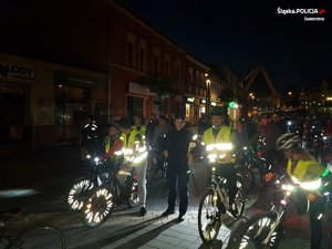 Rowerzyści i policjantka zdjęcie zrobione w nocy