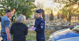 Policjantka na cmentarzu rozmawia z kobietą i mężczyzną