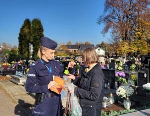 Policjantka na cmentarzu rozmawia z kobietą