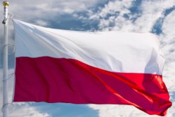Flaga Polski powiewająca na tle błękitnego nieba
