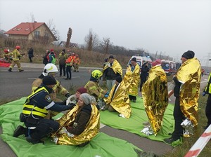 poszkodowani w wypadku, ranni, okryci w koce termiczne, pracownicy służb ratunkowych