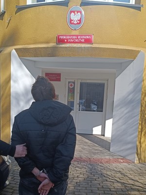 na zdjęciu zatrzymany, zakuty w kajdanki prowadzony do budynku Prokuratury Rejonowej w Jaworznie