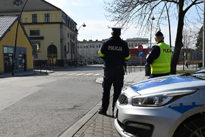 na zdjęciu dwóch umundurowanych policjantów obserwujących przejście dla pieszych