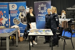 na zdjęciu dwie umundurowane policjantki oraz kobieta w ubraniu cywilnym, które stoją przy stoisku edukacyjnym Komendy Miejskiej Policji w Jaworznie.