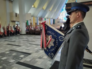 na zdjęciu umundurowany policjant oddający honor oraz sztandar Komendy Miejskiej Policji w Jaworznie