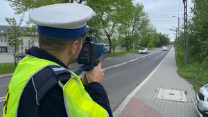 na zdjęciu policjant ruchu drogowego dokonujący pomiaru prędkości