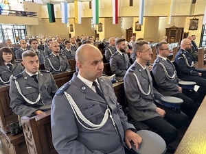 na zdjęciu umundurowani policjanci siedzący w ławach kościoła