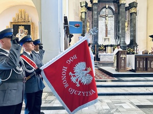 na zdjęciu umundurowani policjanci z pocztem sztandarowym oddający honor. Przy ołtarzu stoi ksiądz.