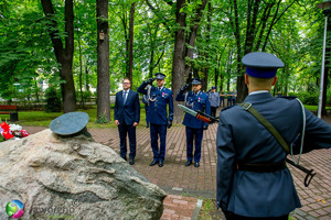 na zdjęciu umundurowani policjanci oddający honor przed pomnikiem oraz stojący obok nich zastępca prezydenta miasta Jaworzna.