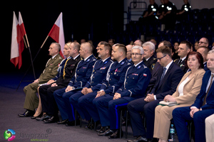 na zdjęciu umundurowani policjanci oraz zaproszeni goście siedzący na krzesłach w hali