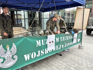 na zdjęciu namiot profilaktyczny Muzeum Techniki Wojskowej oraz trzy osoby w mundurach wojskowych