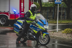 na zdjęciu umundurowany policjant ruchu drogowego, który siedzi na policyjnym motocyklu