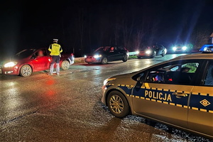 na zdjęciu policjant ruchu drogowego sprawdza na drodze stan trzeźwości kierowcy samochodu