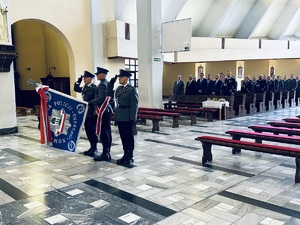 na zdjęciu policjanci w mundurach ze sztandarem oraz policjanci wraz z zaproszonymi gośćmi w kościele