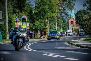 funkcjonariusz WRD na motocyklu w tle radiowóz