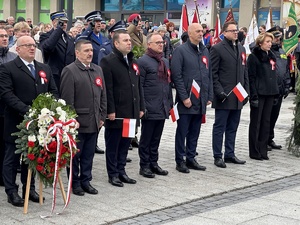 na zdjęciu uczestnicy uroczystości, w tym umundurowani funkcjonariusze stojący z tyłu oddający honor