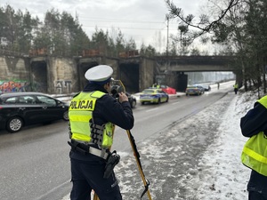 na zdjęciu umundurowany policjant wykonuje pomiary przy użyciu specjalistycznego sprzętu