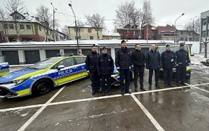 na zdjęciu na tle radiowozów stoją przedstawiciele władz miasta oraz umundurowani policjanci